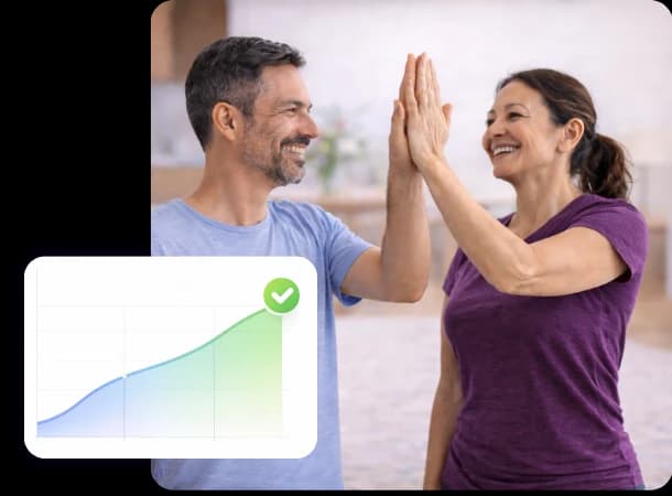 Two people high-fiving after a session, beside a progress chart