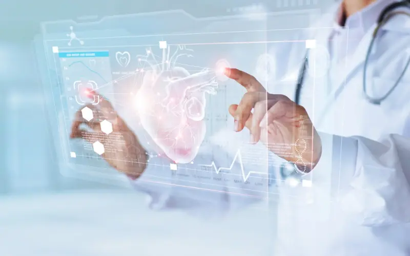 A clinician touches a glowing display of a heart surrounded by an ECG trace.